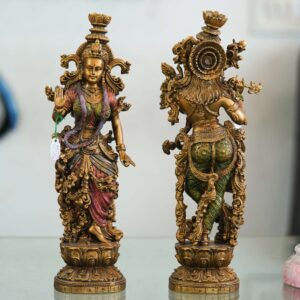 Set of two handcrafted brass statues inspired by Radha Krishna—elegant decorative couple showpiece for home décor and gifting.