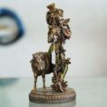 Brass Krishna with cow idol—flute playing Lord Krishna symbolizing love, purity, and harmony, ideal for home décor and gifting.